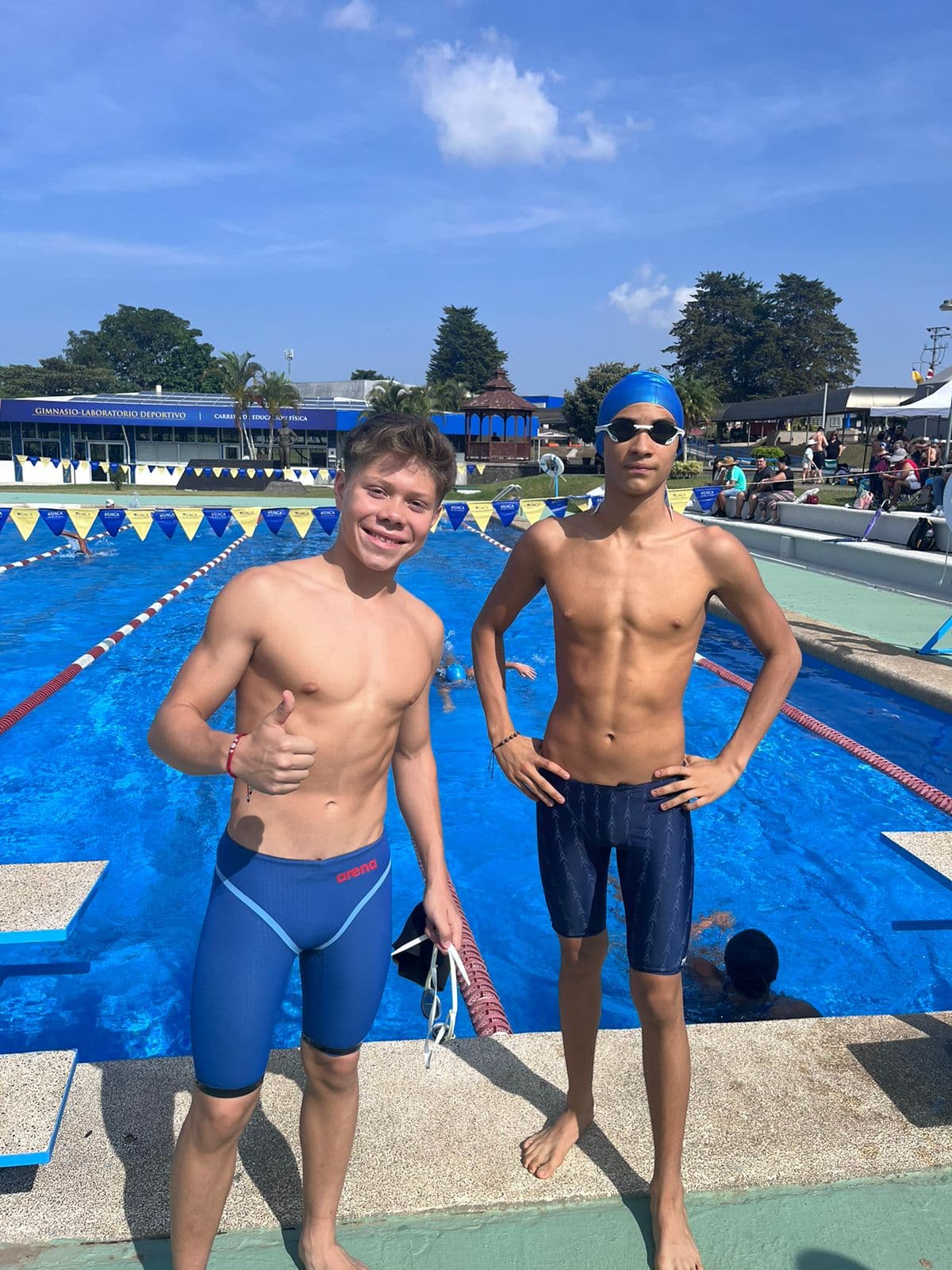 Dos nadadores junto a una piscina al finalizar una competencia